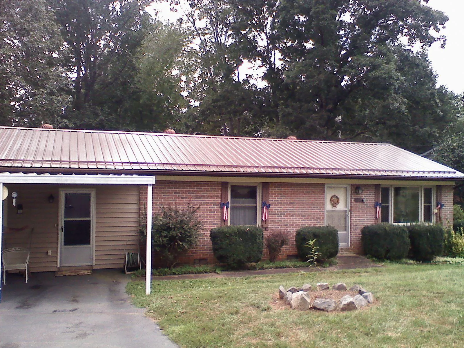 Bronze metal roof and carport on a brick ranch home — Roof Repair work by our crew in Davidson