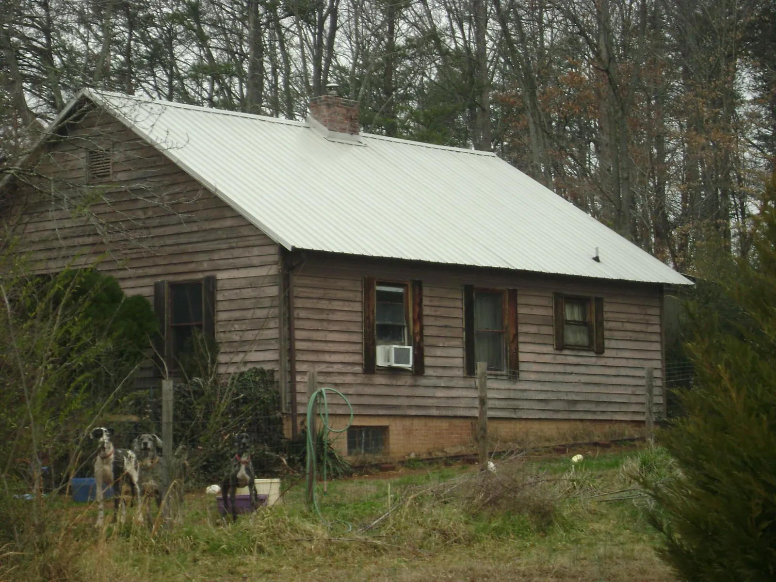White metal roof on an old wood sided farmhouse, from a Metal Roof Installation job in Davidson